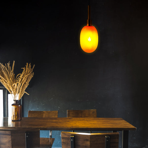 Подвесной светильник в форме эллипсоида с золотыми деталями в современном интерьере гостиной, создаёт уютную атмосферу.