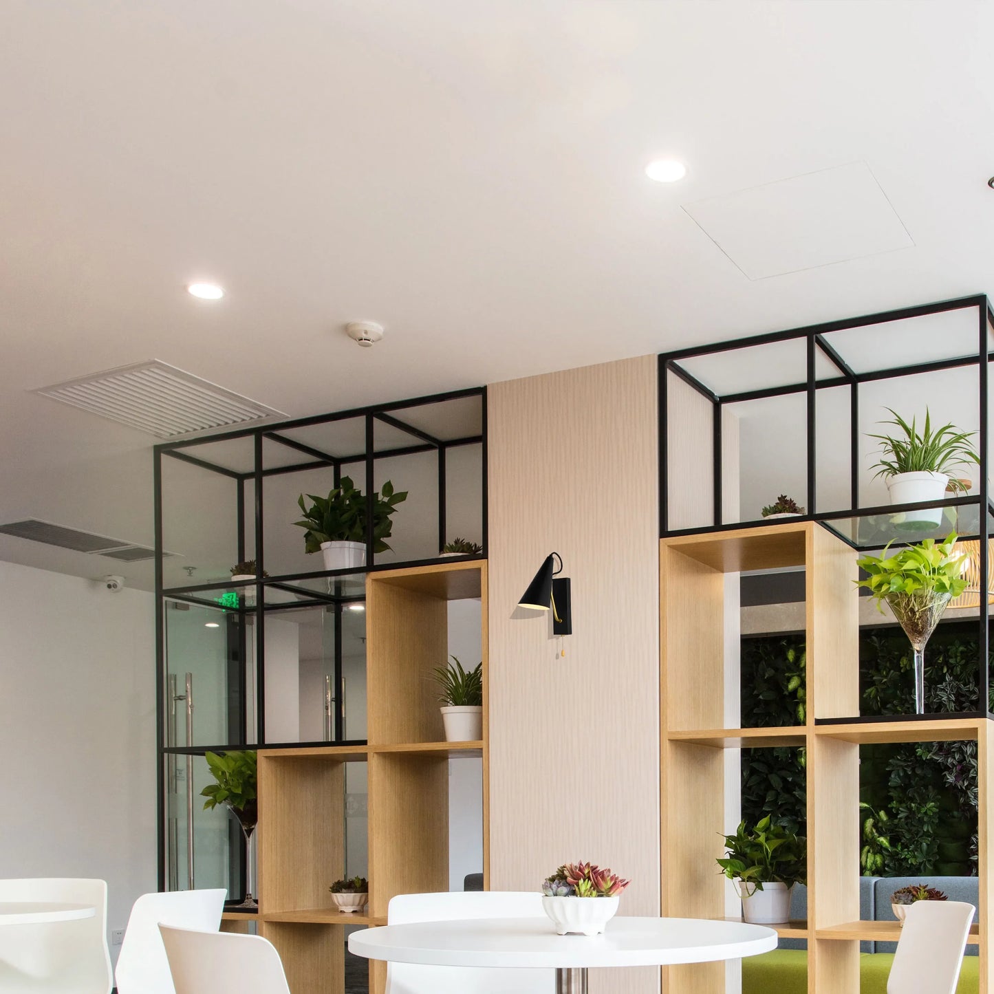 A mix of spotlights and a black conical wall light provide bright, focused illumination in this modern interior.