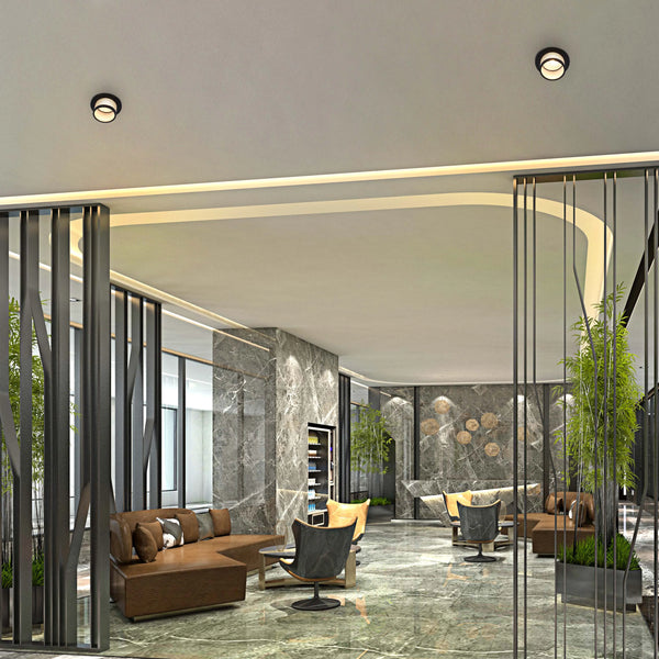 A modern lobby with circular ceiling lights. The space features elegant, recessed lighting around a curved architectural feature.
