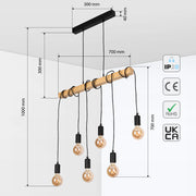Industrial pendant light with five exposed bulbs hanging from a wooden beam, suspended by black cables.