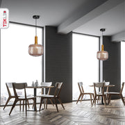 Golden bronze metal amber glass cylinder pendant light short with e27 fitting in indoor setting cafe table top