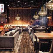 Golden bronze metal amber glass globe pendant light s with e27 fitting in indoor setting cafe