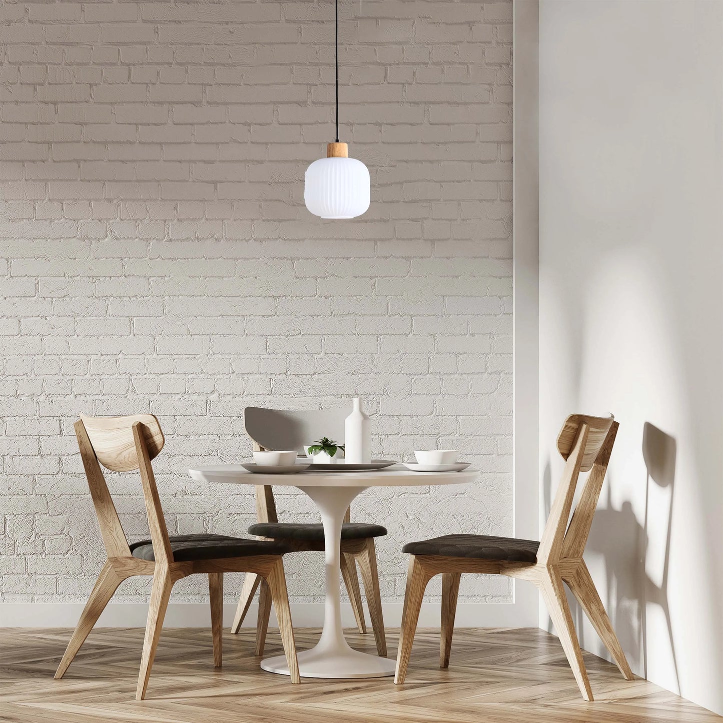 A contemporary pendant light with a white ribbed shade and wooden top, hanging above a round table in a modern dining setting.