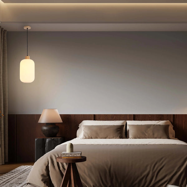 Ambient lighting with a hanging pendant lamp and a table lamp creates a warm and inviting atmosphere in this bedroom.