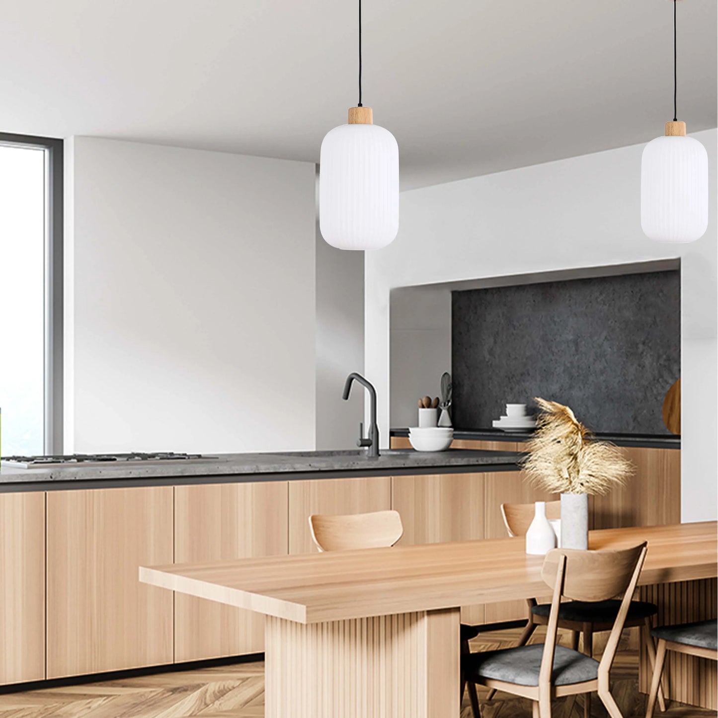Two stylish pendant lights hang above a wooden dining table in a modern kitchen, adding a touch of elegance to the space.