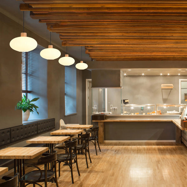 A restaurant interior lit by suspended globe lights and overhead spotlights creating a warm and inviting atmosphere.